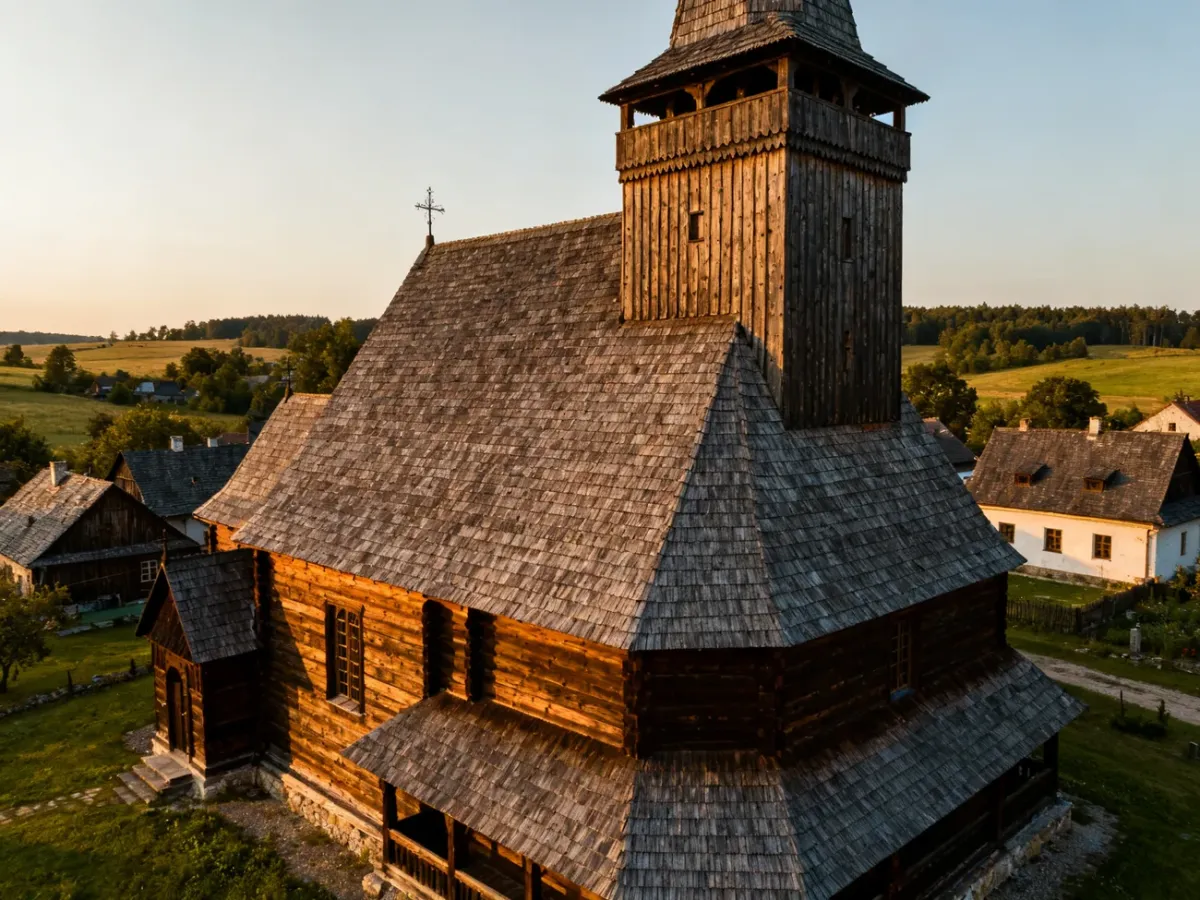 Drewniany kościół UNESCO z wieżą i zabudową wiejską