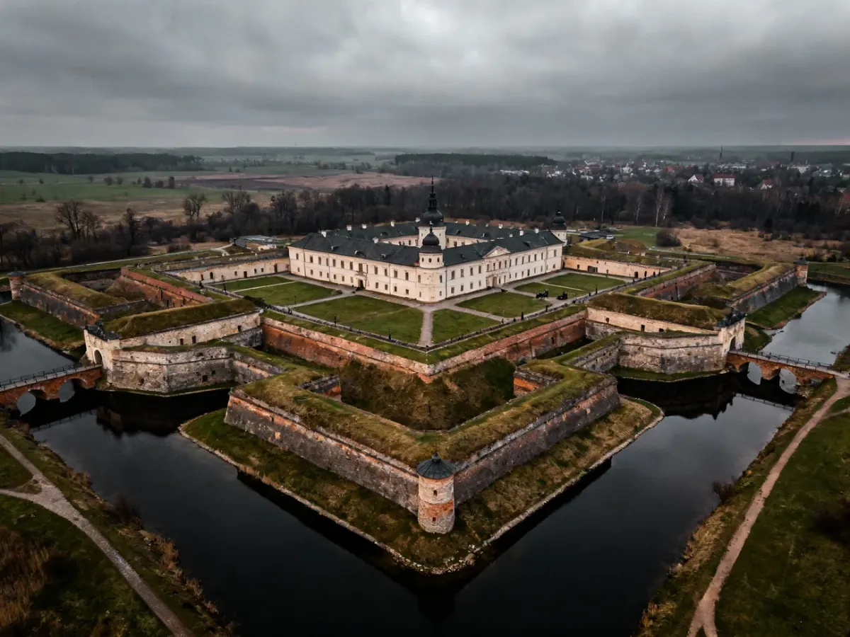 Rozległa polska twierdza z bastionami, fosą i wałami widziana z lotu ptaka